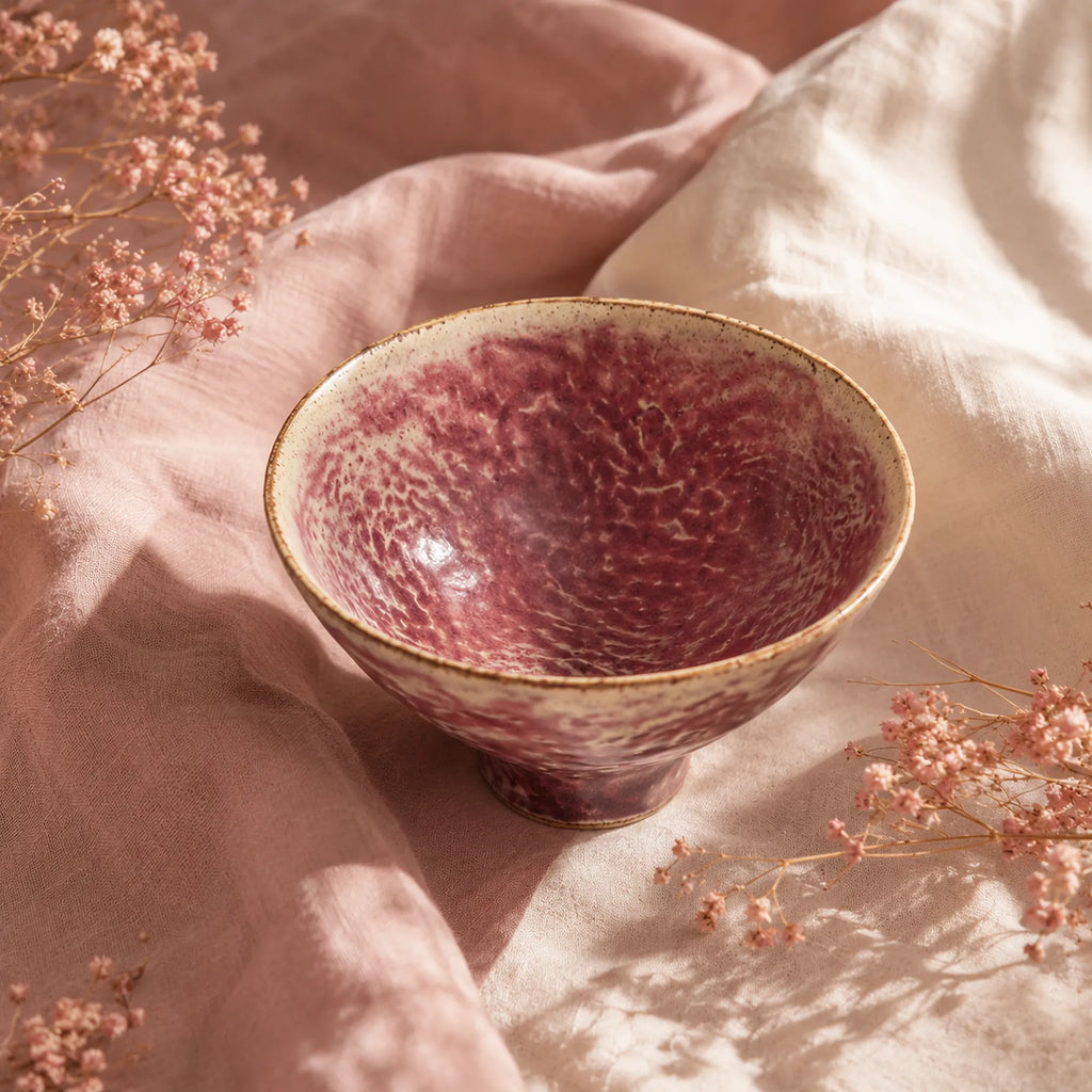 Coral pink ceramic dessert bowl styled on a minimalist table
