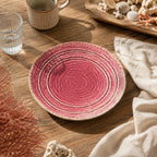 Coral pink ceramic dinnerware styled on a bright dining table
