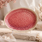 Vibrant coral pink ceramic oval plate with layered glaze texture