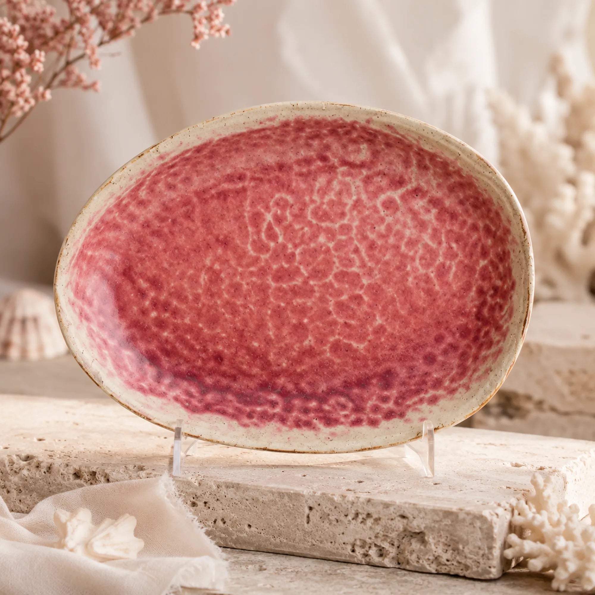 Vibrant coral pink ceramic oval plate with layered glaze texture