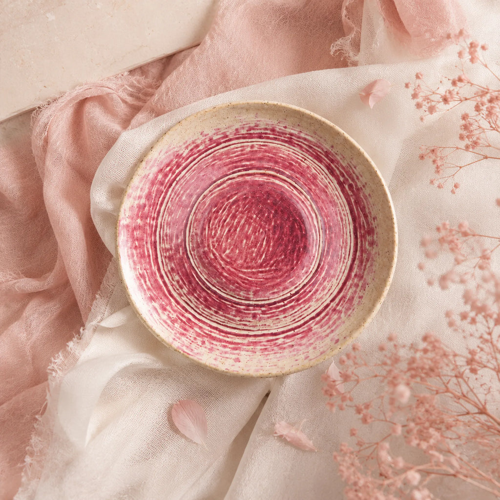 Coral pink ceramic pasta bowl styled in a modern dining setting