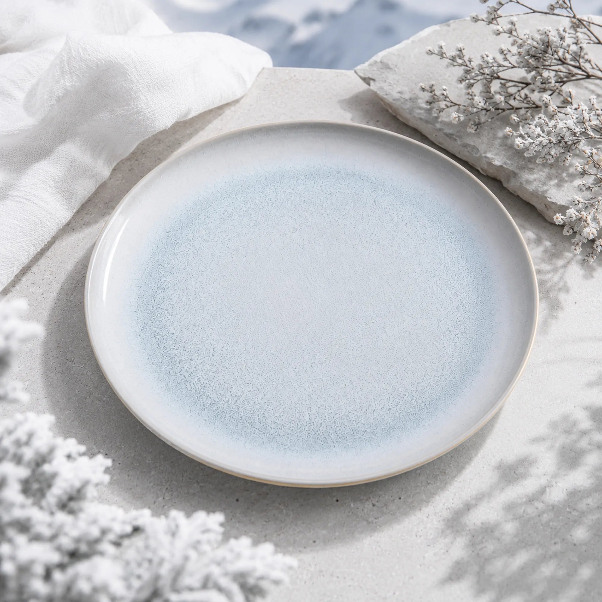 Mist blue ceramic dinnerware styled on a natural dining table
