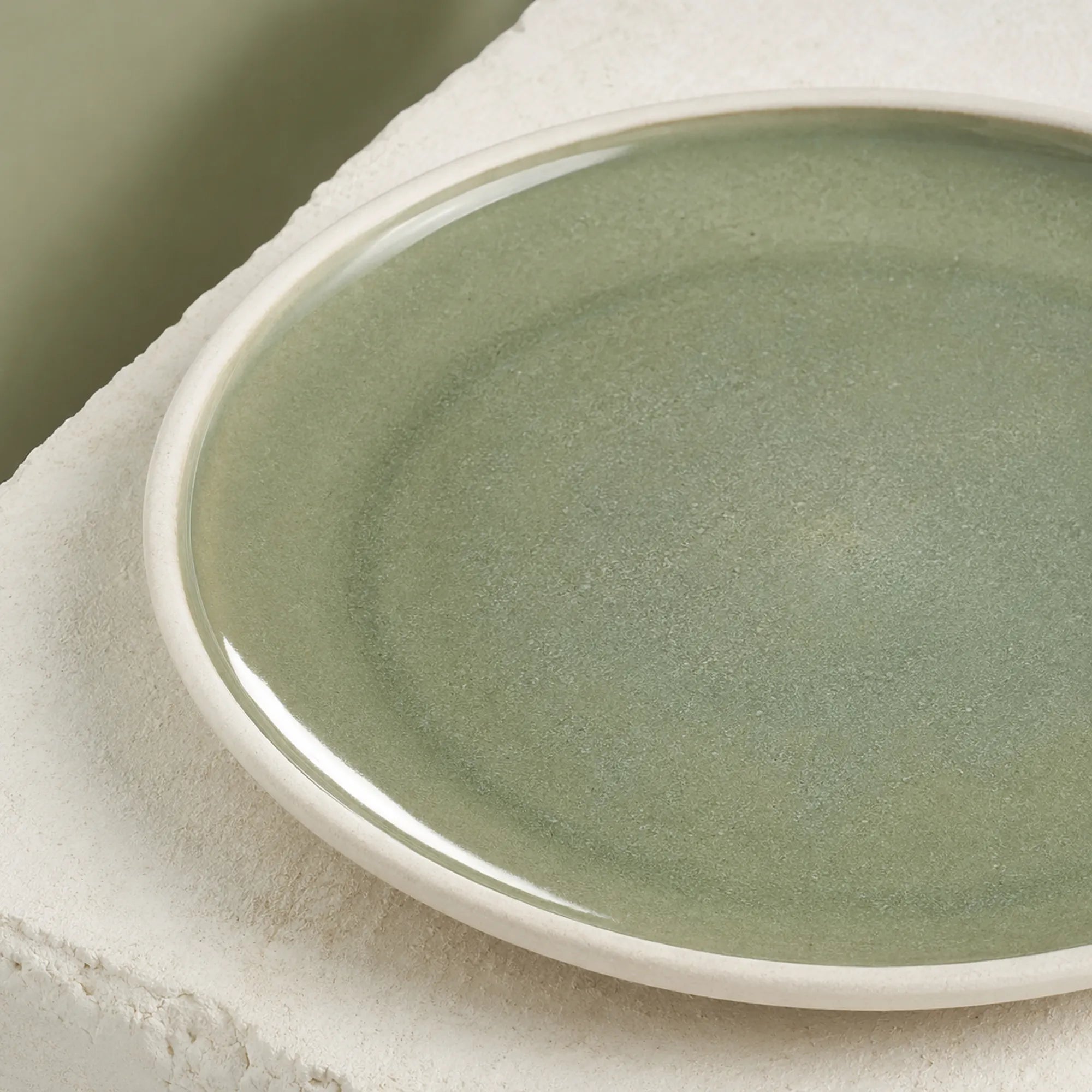 Close-up texture detail of moss green ceramic dinner plate