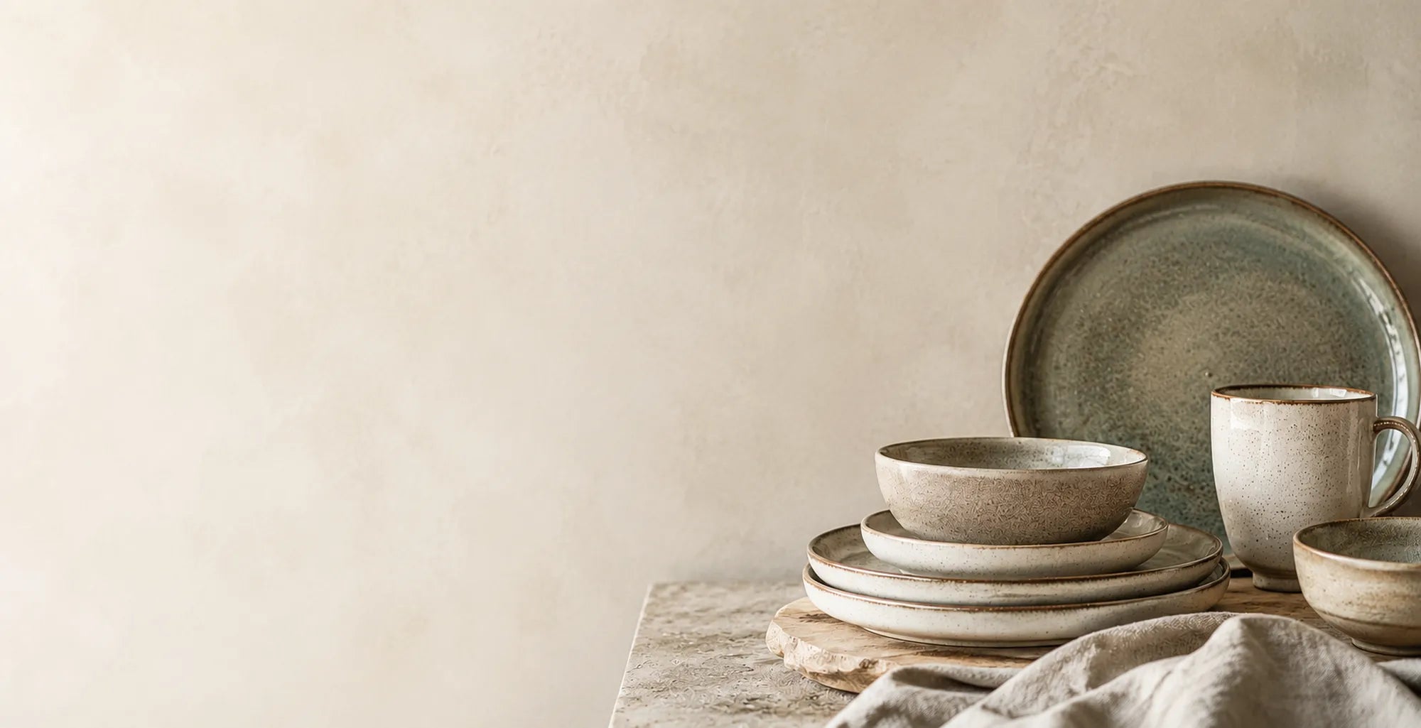 Modern ceramic tableware displayed in a warm, minimalist setting