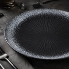 Close-up matte texture of obsidian black ceramic dinner plate