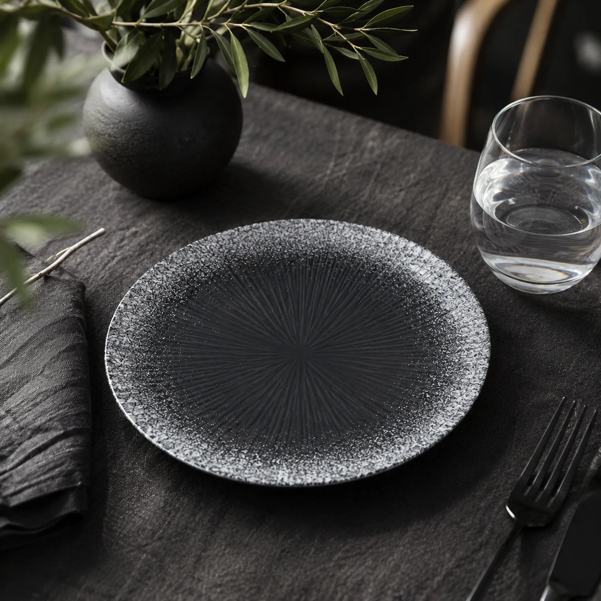Obsidian black ceramic dinnerware styled on a moody dining table