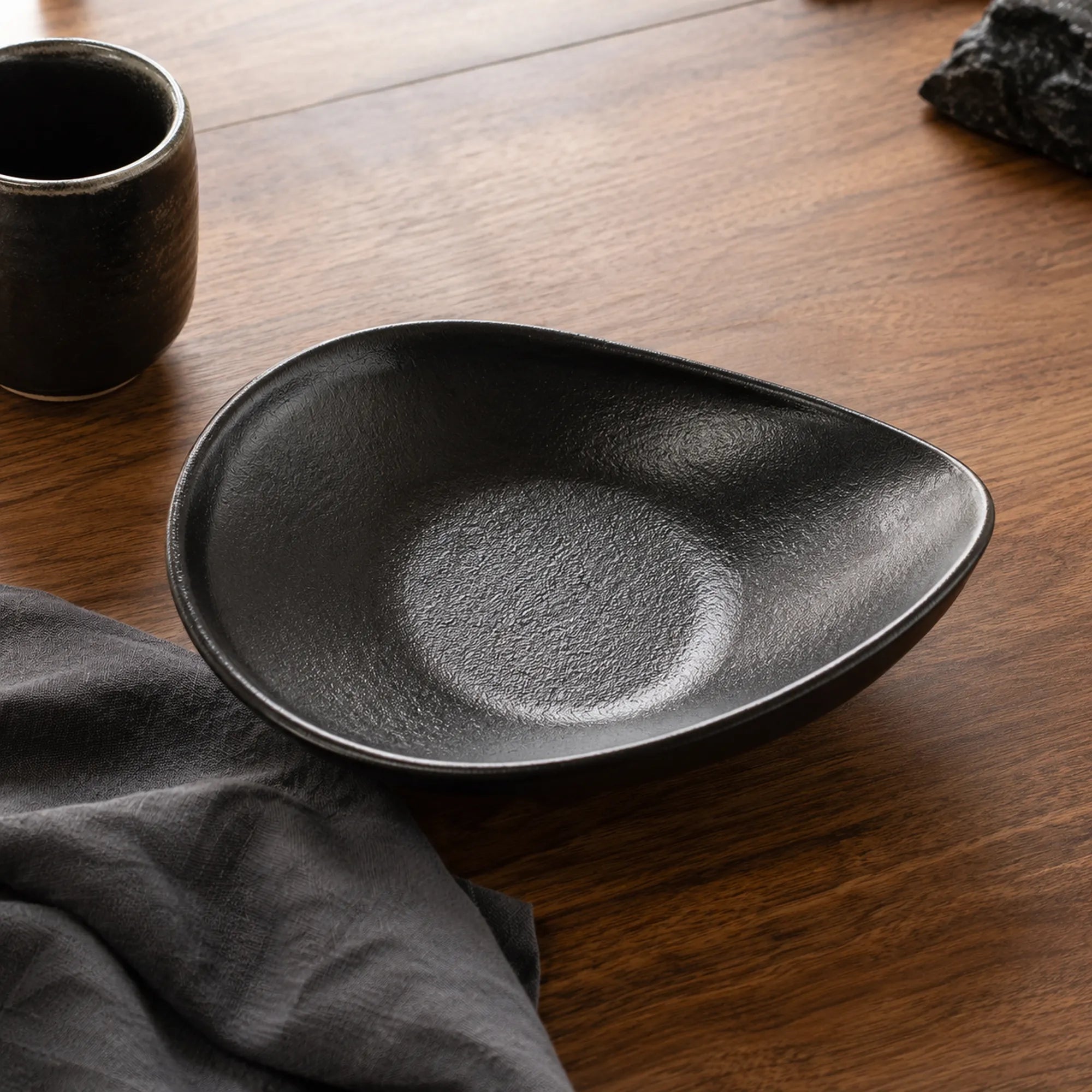 Obsidian black ceramic oval plate styled in a modern dining setting