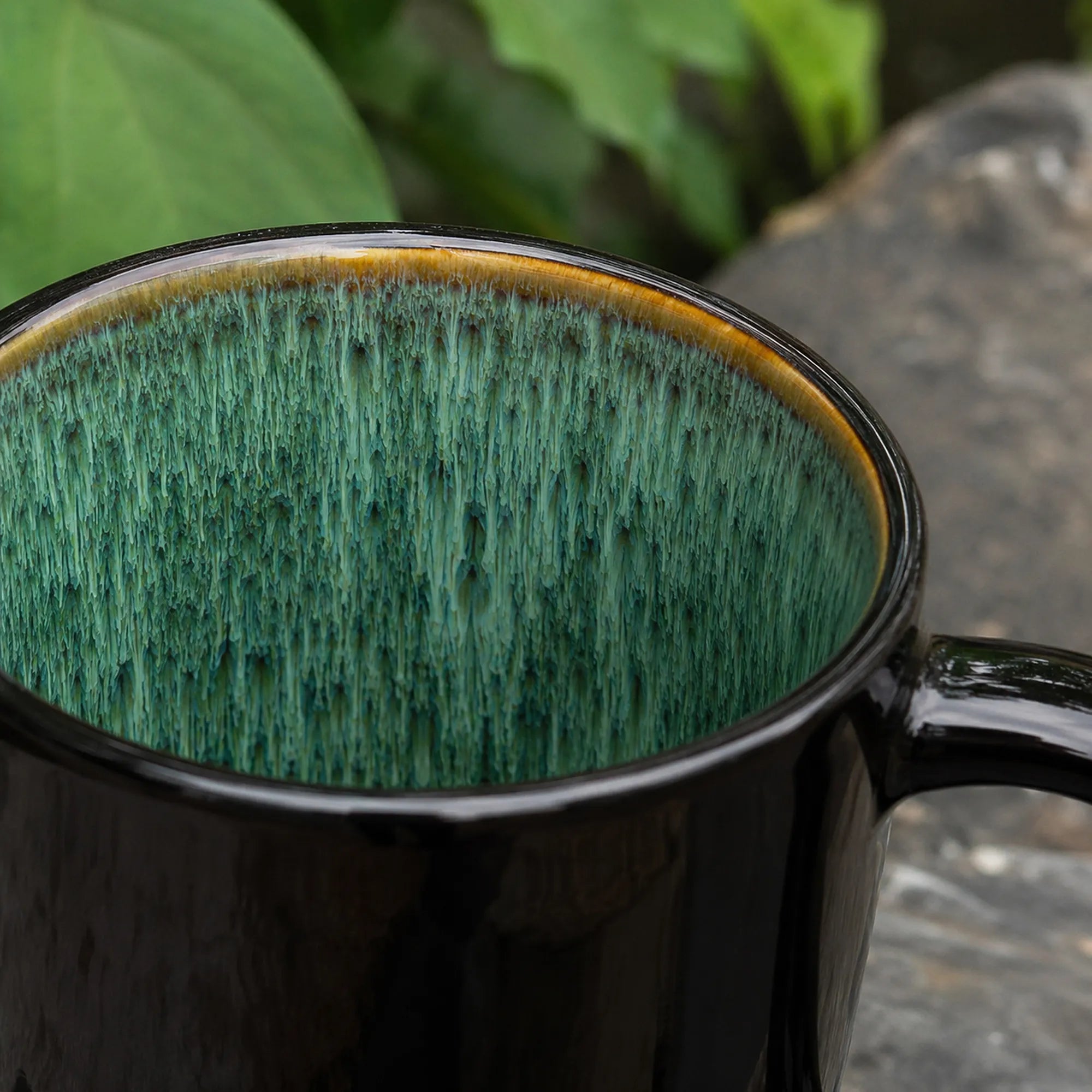 Close-up texture detail of peacock green ceramic coffee mug