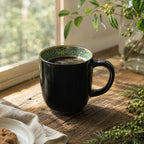 Peacock green ceramic coffee mug styled on a wooden table
