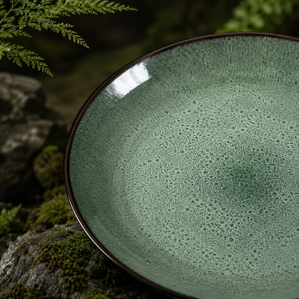 Close-up texture detail of peacock green ceramic dinner plate