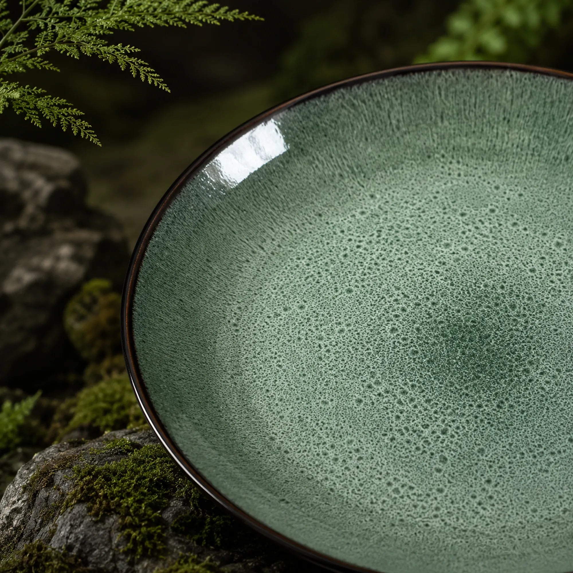 Close-up texture detail of peacock green ceramic dinner plate