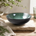 Peacock green ceramic pasta bowl styled on a modern dining table