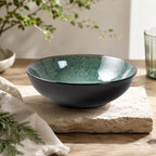 Peacock green ceramic pasta bowl styled on a modern dining table