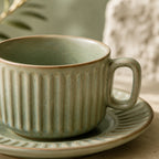 Close-up texture detail of sage green ceramic coffee cup set