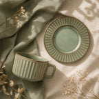 Sage green ceramic coffee cup set styled on a modern coffee table