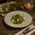 Sage green ceramic dinner plate styled with fresh food