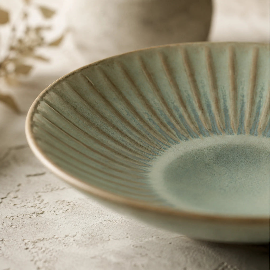 Close-up texture detail of sage green ceramic pasta plate