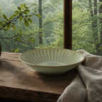 Sage green ceramic pasta plate styled on a modern dining table