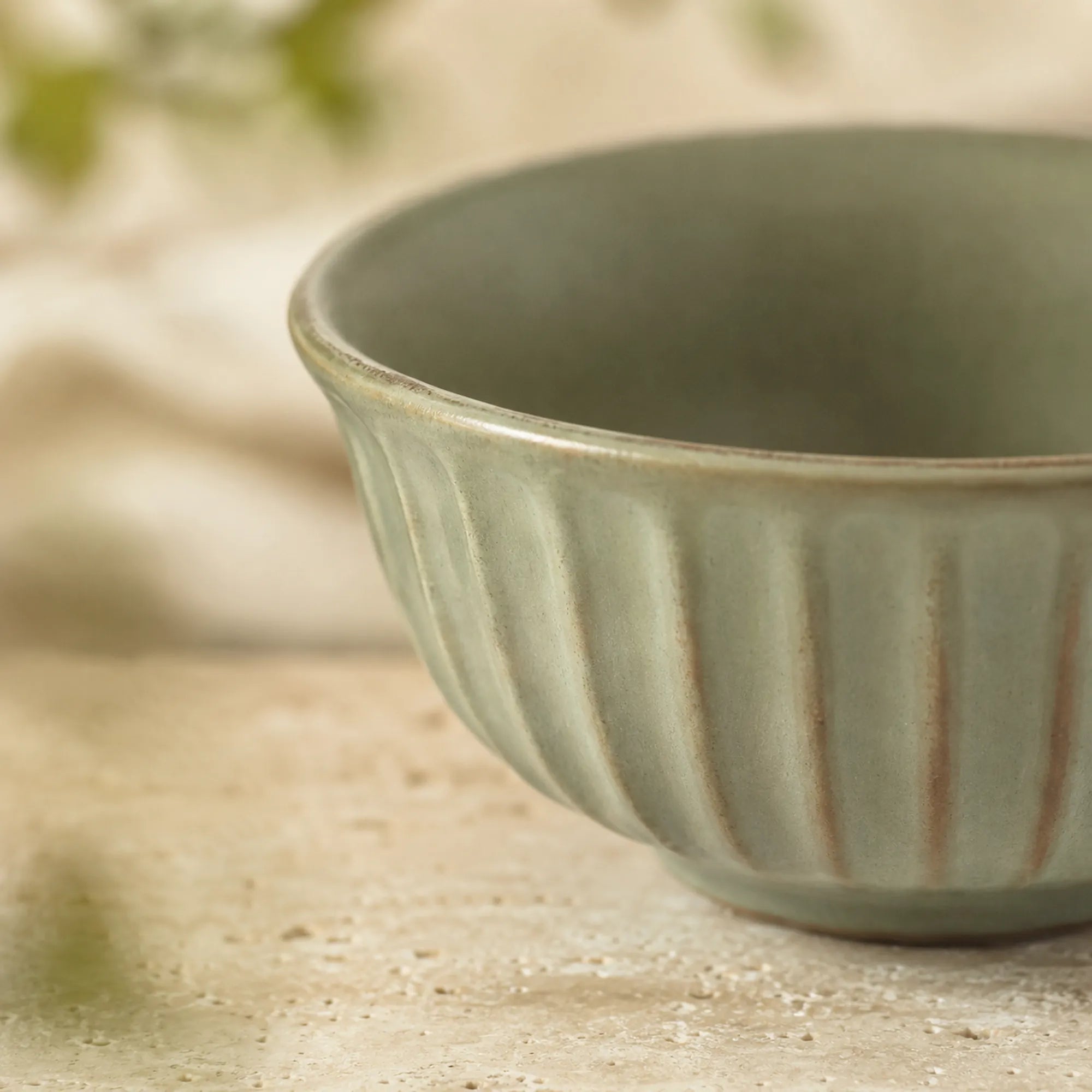 Close-up texture detail of sage green ceramic rice bowl