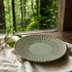 Sage green ceramic dinnerware styled on a calm dining table