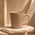 Warm sand beige ceramic coffee mug with smooth glazed finish