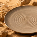 Close-up spiral texture of sand brown ceramic dinner plate