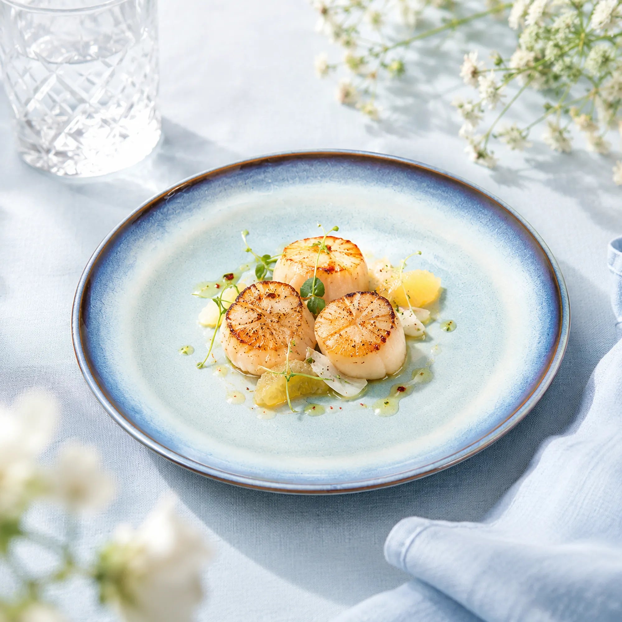 Airy sky blue ceramic dinner plate styled with fresh cuisine