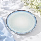 Sky blue ceramic dinnerware styled on a minimalist dining table